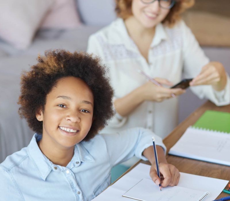 radiate happiness happy mixed race teen schoolgirl smiling at camera while having a lesson with.jpg
